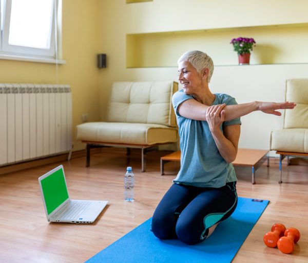 Senior woman doing yoga in living room